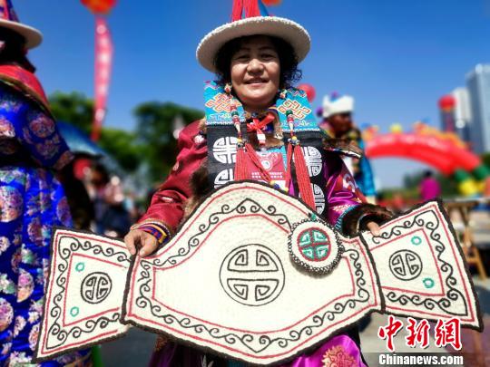 图为蒙古族“绣娘”展示作品马鞍垫?！±铞?摄