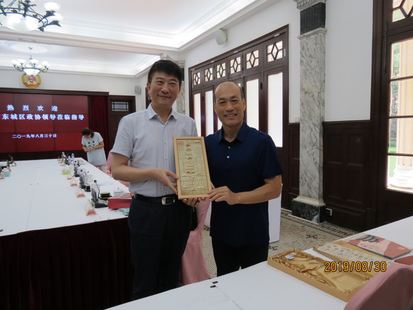 宋铁健主席向丁宝定主席赠送东城区文化宣传册