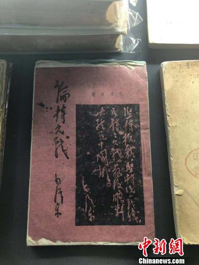 一本用白、红、蓝等五种颜色纸张印刷而成的《论持久战》。　李庭耀 摄