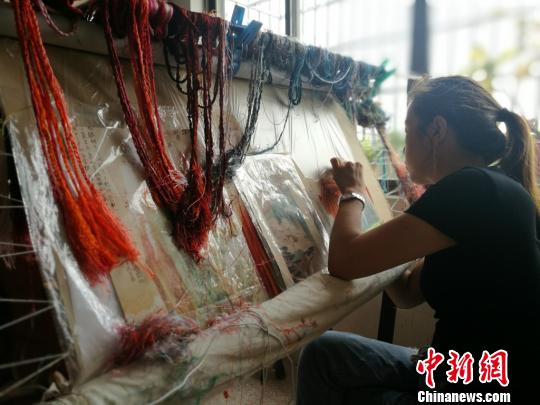 曾经坐在绷架前一心刺绣不问世事的绣娘们也开始走出绣房，接触市场?！≈由?摄