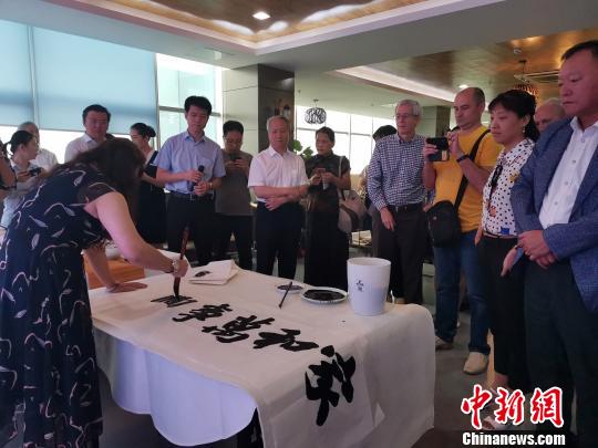 图为，庆祝新中国成立70周年外国专家座谈会暨驻济外国人才中秋节沙龙观上，外国专家观看书法表演?！∷锖觇?摄