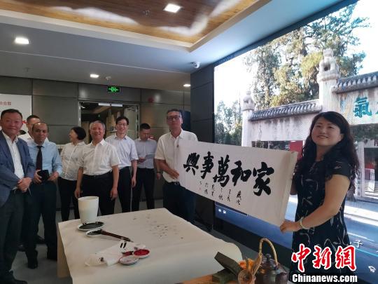 图为，庆祝新中国成立70周年外国专家座谈会暨驻济外国人才中秋节沙龙观上，外国专家展示获赠书法作品?！∷锖觇?摄