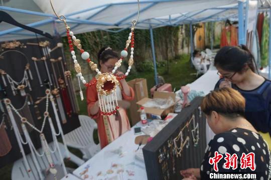 游客在首饰摊位前驻足?！≌澎匣?摄