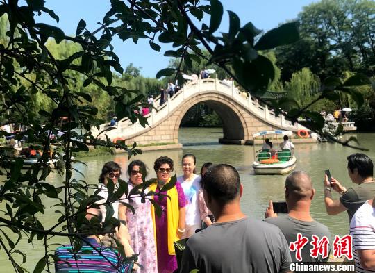 图为中外游客追逐月亮下扬州，领略“月亮城”文化魅力?！〈藜衙?摄