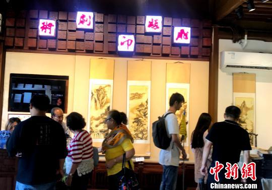 图为中外游客近距离感受非遗文化。　崔佳明 摄