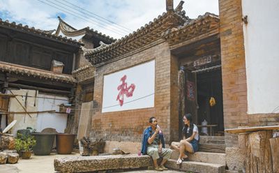 73岁的杨国保在位于云南省石屏县异龙镇符家营村的家中与放暑假的孙女聊天。新华社记者 江文耀摄