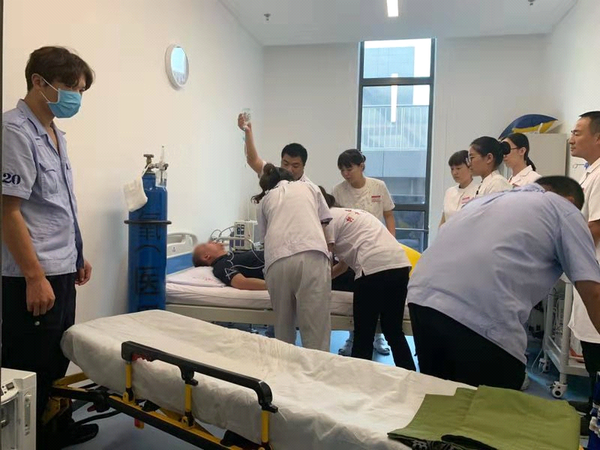 图为9月17日下午3时许，北京冬奥组委办公区“红十字救护站”医护人员、“红十字博爱救护队”队员协同赶来的急救车医务人员对患者进行有关检测和处理