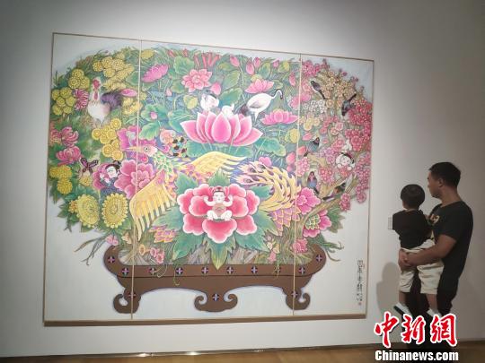 一位父亲带着孩子观看展览?！√菩∏?摄