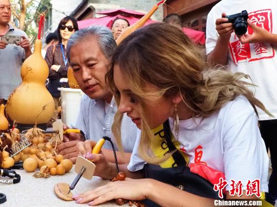 佳丽现场体验非遗?！÷佬铝?摄