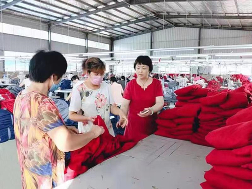 纵梅在扶贫车间里现场指导，解决贫困群众工作中的难题