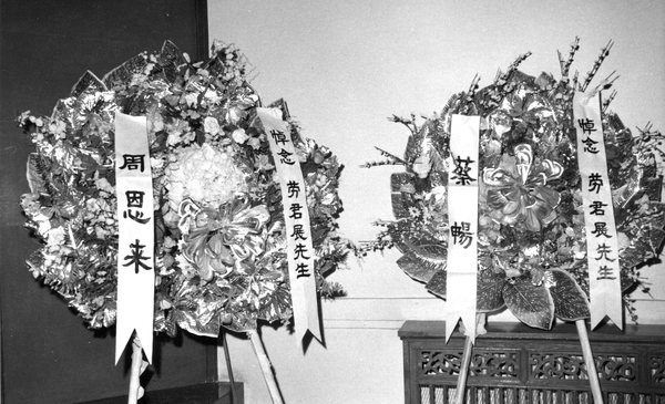 9--1976年1月8日，在劳君展先生追悼会的会场上，摆放着全国政协周恩来主席所献的花圈