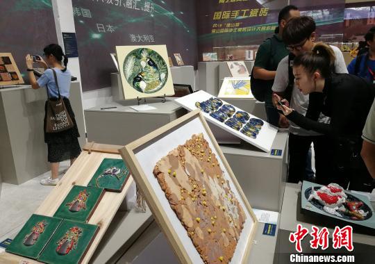 市民正在观看展出的手工瓷砖设计作品?！〕叹拔?摄