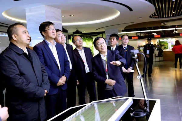 图为民盟中央农业委员会委员、杨凌示范区科技创新和转化推广局副局长、杨凌示范区科创中心（杨凌大学科技园）建设领导小组办公室常务副主任王博文（右一）向前来参观的新疆维吾尔自治区党委常委、副主席艾尔肯?吐尼亚孜一行介绍情况。