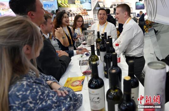 资料图：第二届进博会上，俄罗斯参展商向参观者推介俄罗斯红酒。<a target='_blank' href='http://www.chinanews.com/'>中新社</a>记者 毛建军 摄