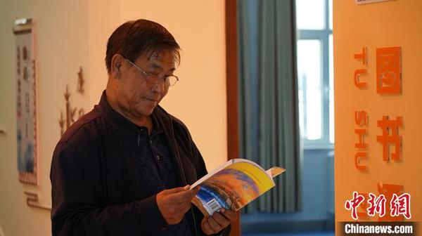 图为社区居民在图书漂流站看书?！∥航ň?摄