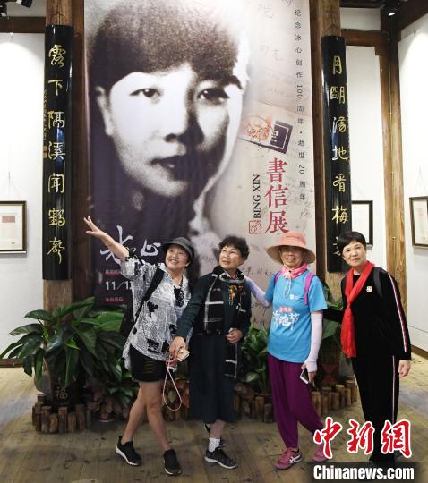 观众在展出的冰心青年时期黑白老照片前合影。　记者刘可耕 摄