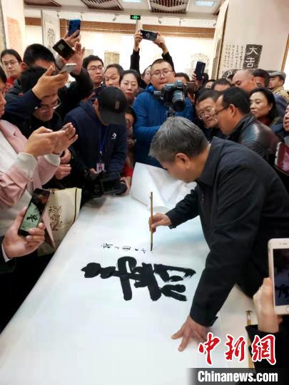 山东省书法家协会主席顾亚龙在现场展示书法?！∏锔?摄