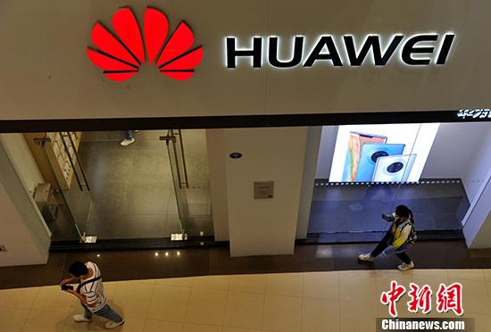 资料图：市民从华为产品专卖店旁经过。 <a target='_blank' href='http://www.chinanews.com/'>中新社</a>记者 张斌 摄