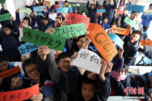 资料图：中学生们用八国语言书写“谢谢”。周小云 摄