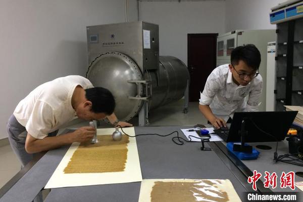 技术人员对“圣旨”原件进行分析采样。(资料图) 钟欣 摄