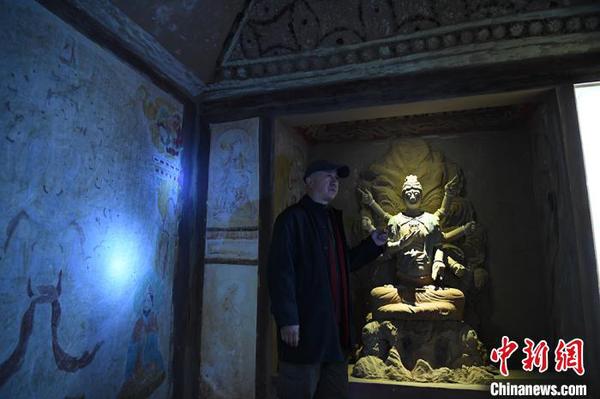 图为许林介绍洞窟壁画及佛头复原过程?！∥航ň?摄