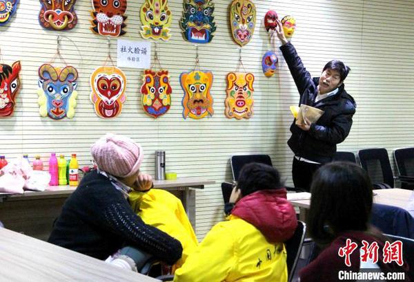 资料图：济南侯氏社火脸谱第六代传人侯志新向学生讲授社火脸谱绘制工艺?！≌韵?摄