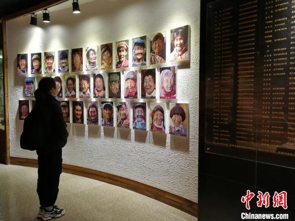 图为独龙族博物馆的文面女照片墙。　胡远航 摄