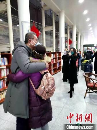 资料图：图为山东首批医疗队深夜集结支援武汉，医护人员出发前和家属拥抱告别。　邱江波 摄