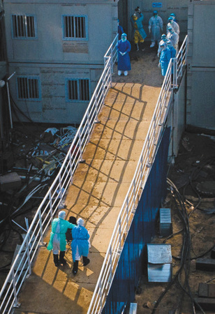 1 4日，医护人员将患者送入火神山医院病房。