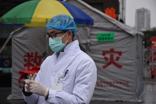 戴上一次性手套、一次性口罩、一次性帽子，穿着白大褂的谭晓鹏开始了一天的工作