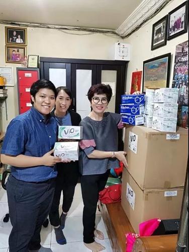 江春云（左）和蔡炜莉（中），在印尼巨港一家药店寻找医疗物资。