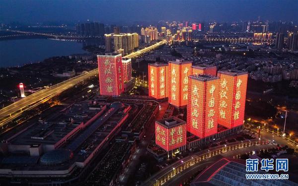 2月12日，武汉体育中心附近高层建筑外墙打出“武汉必胜”等字样（无人机照片）。 新华社记者 肖艺九 摄