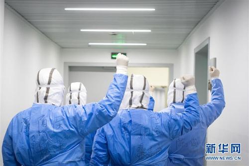 2月17日，来自江苏医疗队的杨洁、张志俊、李飞、汤建伟、陈俊在进舱前加油打气。 武汉体育中心方舱医院从2月12日收治首批患者以来，运行平稳有序，患者在医护人员的精心照顾下调养身体，等待痊愈。记者夜晚来到武汉体育中心方舱医院，用镜头记录舱内瞬间。 新华社记者肖艺九摄