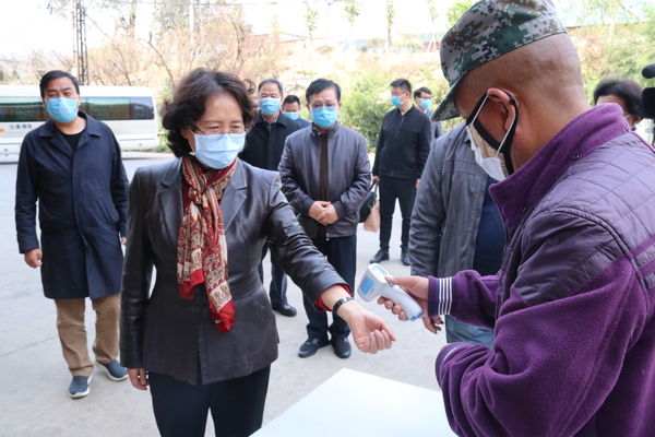 1：李江在云南东骏药业有限公司医药物流中心调研，测量体温