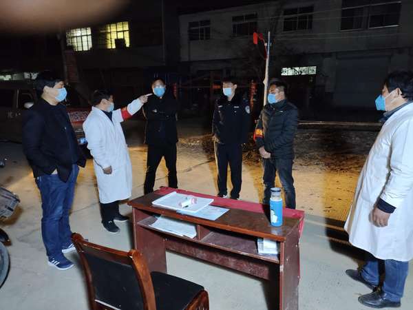 冯营乡党委副书记、乡长欧中锋（左一）到卡点查看夜间值班情况