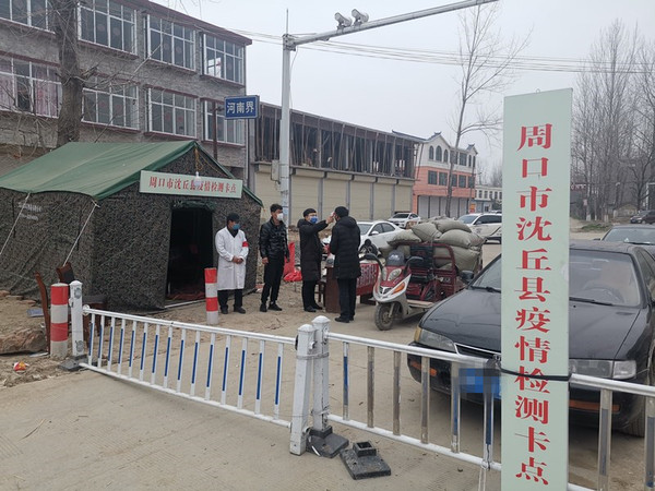 冯营乡天桥村省界卡点处，工作人员为群众测量体温