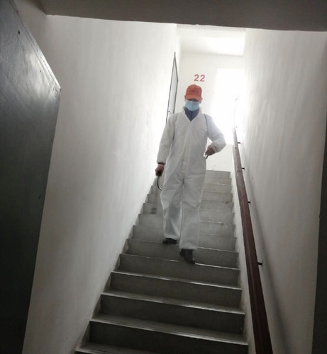 图为毛丽萍的丈夫在社区做志愿者，为楼栋消毒。