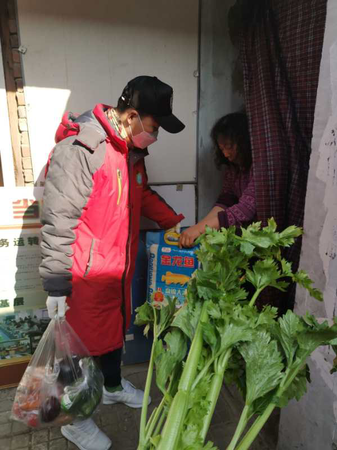 武鑫将买好的蔬菜送给大姐