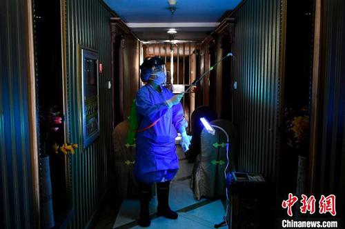 资料图。定点隔离酒店人员对酒店楼道进行消毒?！∥ち?摄