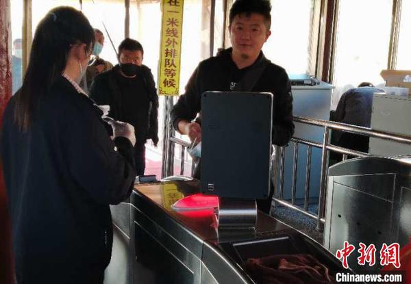 图为游客进景区前测量体温。甘肃嘉峪关市文旅局供图