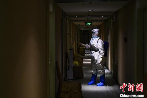 冯丕文穿着厚厚的防护服在酒店消毒?！∥淇〗?摄