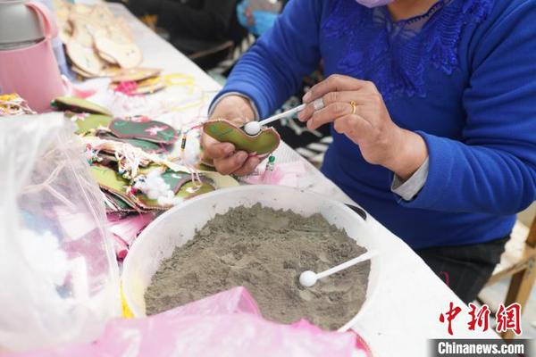 图为工人在装青绣防疫荷包里的中草药。　文思睿 摄