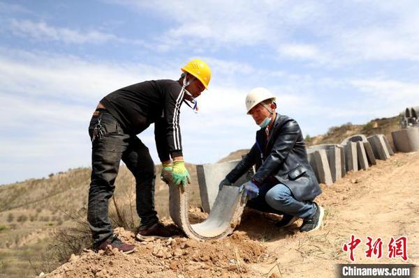 专业工人将水泥排水管手工搬运到排水道内?！∮诰?摄