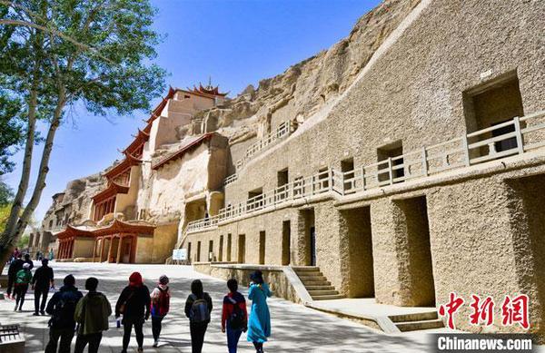 游客预约成功后，在采取了体温测量、佩戴口罩等防控措施后，有序进入敦煌莫高窟景区参观游览?！⊥醣笠?摄