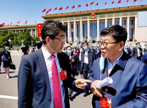 特邀委员记者韩方明（右）在天安门广场就国际疫情合作联防联控情况现场采访医药卫生界委员高福。 特邀委员记者 王众一 摄