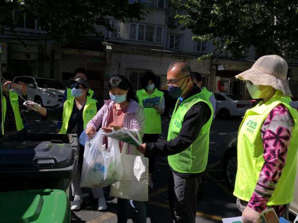 委员们帮助居民对垃圾进行分类投放