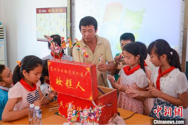 张明铁到学校为孩子们教授“妆糕人”制作技艺。　张艺欣 摄