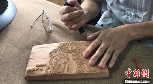 图为国家级非物质文化遗产传承人黄小建正在创作作品 江杨烨 摄