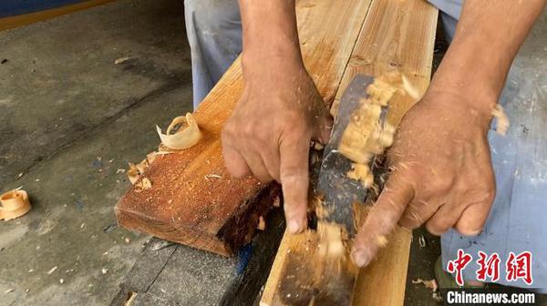 俞国炎正在刨船板。　钱晨菲 摄
