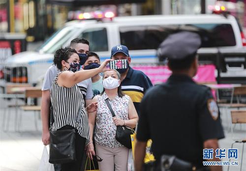 7月23日，人们戴着口罩在美国纽约时报广场拍照留念。 美国约翰斯·霍普金斯大学23日发布的新冠疫情最新统计数据显示，美国累计确诊病例超过400万例。数据显示，截至美国东部时间23日15时34分（北京时间24日3时34分），美国累计确诊病例4007859例，累计死亡病例143846例。 新华社记者 王迎 摄